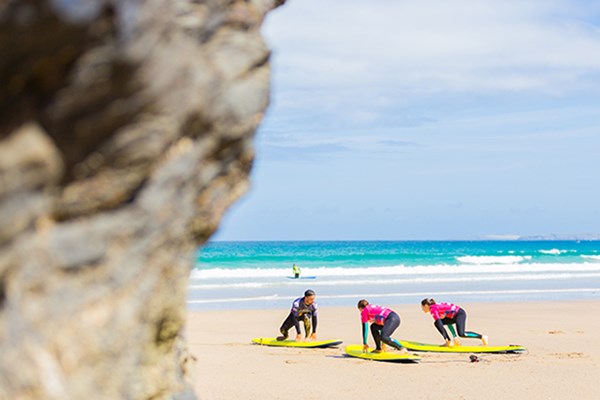 Two people doing a surf lesson in Cornwall taught by an experienced instructor