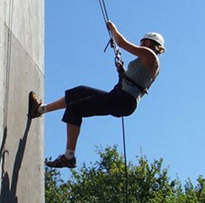 A person abseiling vertically down a wall