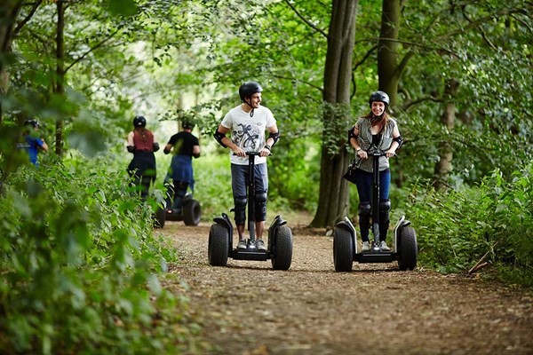 People enjoying riding the segway through the forest