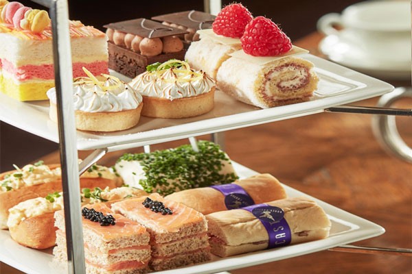 Colourful selection of savoury treats and cakes on a multi-tiered plate