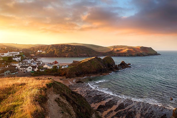 Beautiful orange sunset over rocky land and sea in Devon