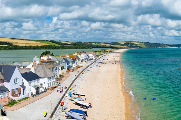 Colourful seaside town, row of houses next to a strip of beach and blue sea, Devon