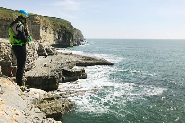 Person coasteering along the Jurassic Coast in Poole, Bournemouth