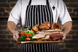 Sunday Roast Sharer with a Glass of Wine for Four at a British Pub or Bar Image 1