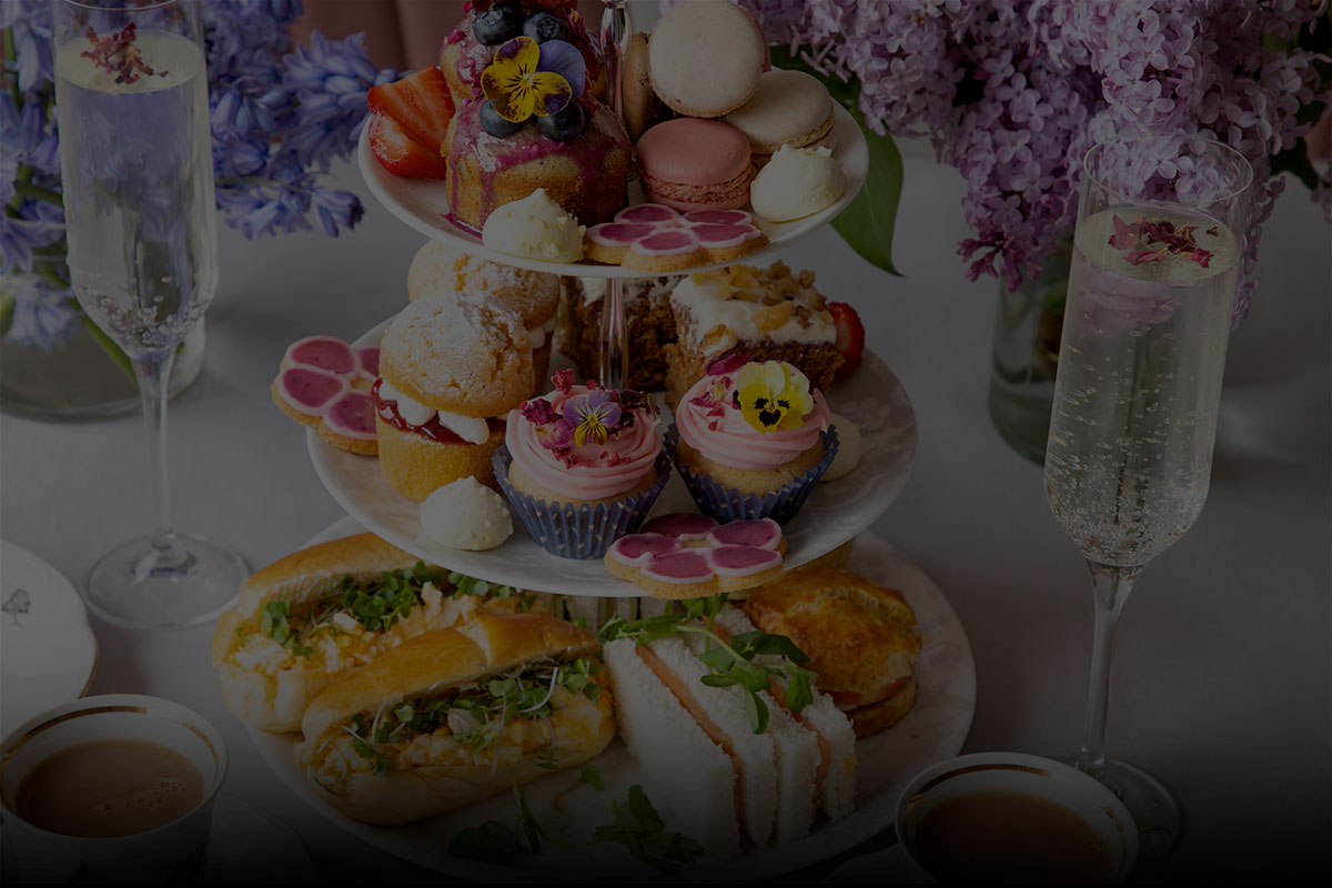 Afternoon tea stand with champagne and luxury cakes, scones and sandwiches